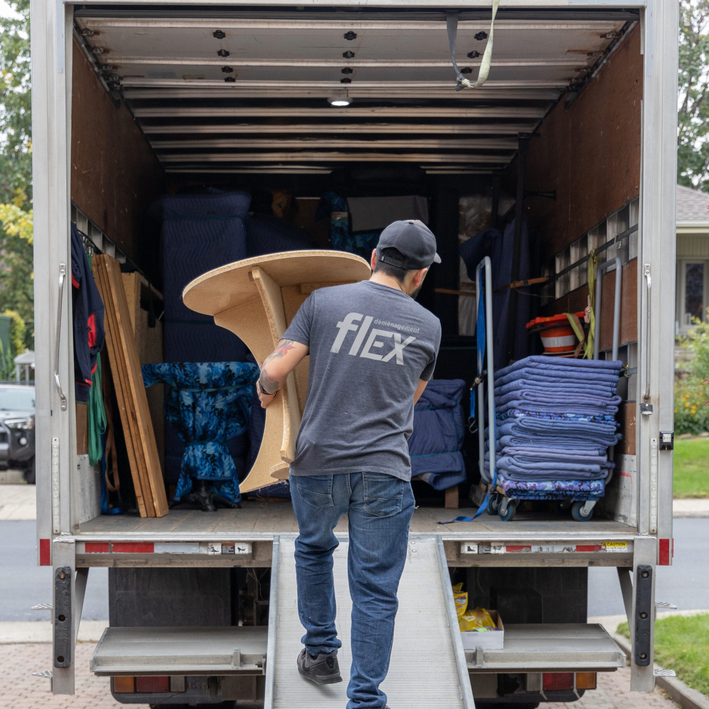 A Flex Mover carefully loading a clean, well-maintained truck in Greater Montreal, showcasing the professionalism and care taken with customers' belongings. - Un déménageur de Flex charge soigneusement un de nos camion propre et bien entretenu dans la région du Grand Montréal, illustrant le professionnalisme et le soin apporté aux biens des nos clients.